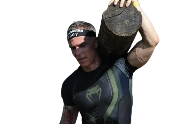 Brian Johnson carrying a log on his shoulder